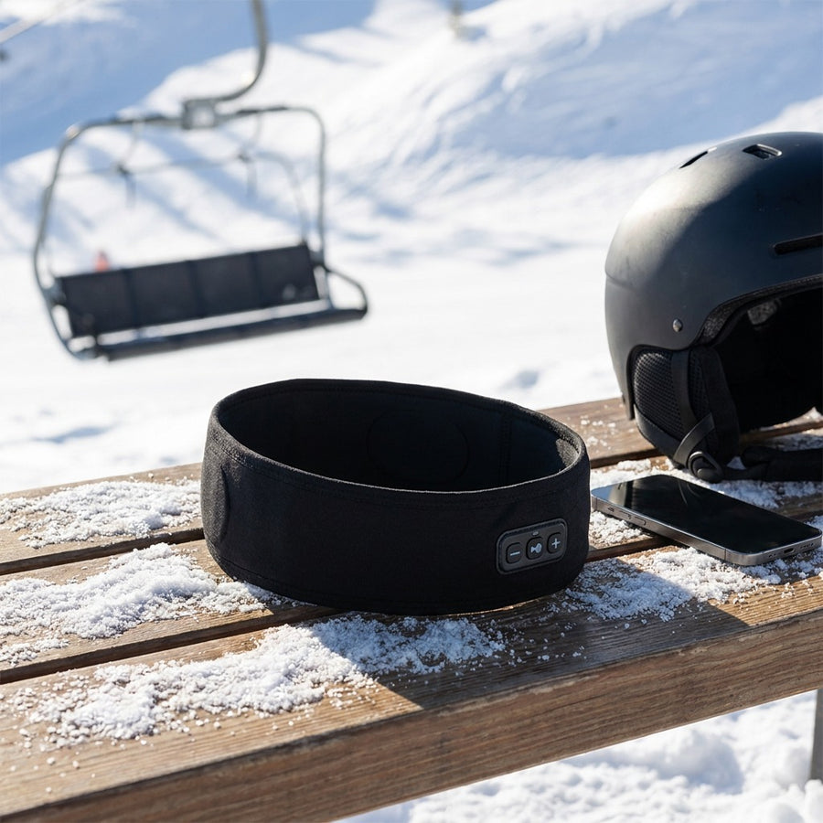 Pannband, hjälm och mobil vid liften