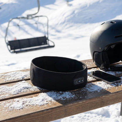 Pannband, hjälm och mobil vid liften